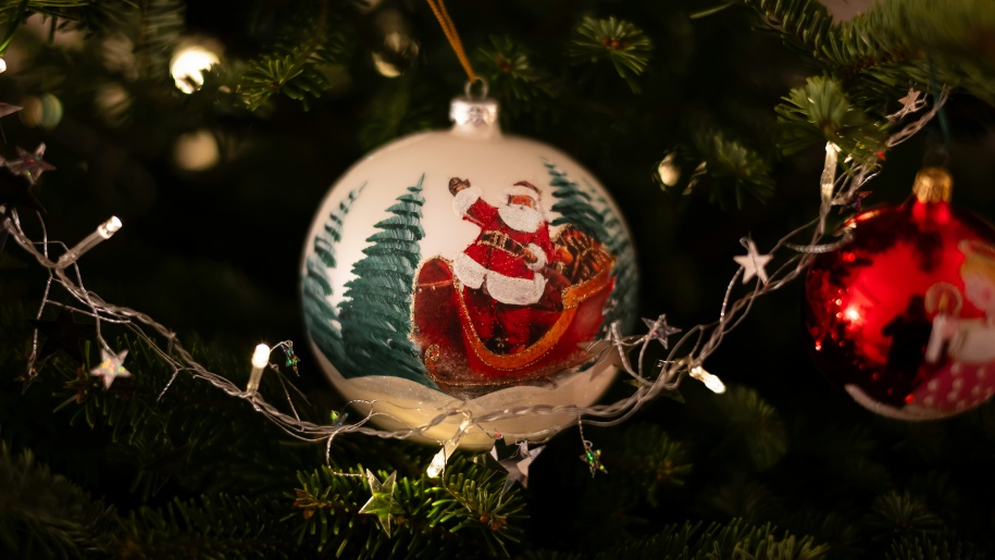 A white Christmas tree bauble with picture of Santa on.