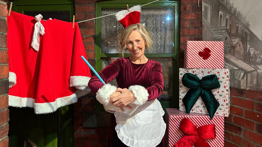 lady dressed as mrs claus, holding a bowl