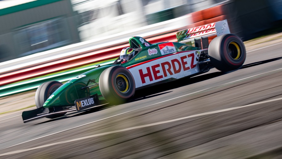 Green and white racing car on a race circuit.