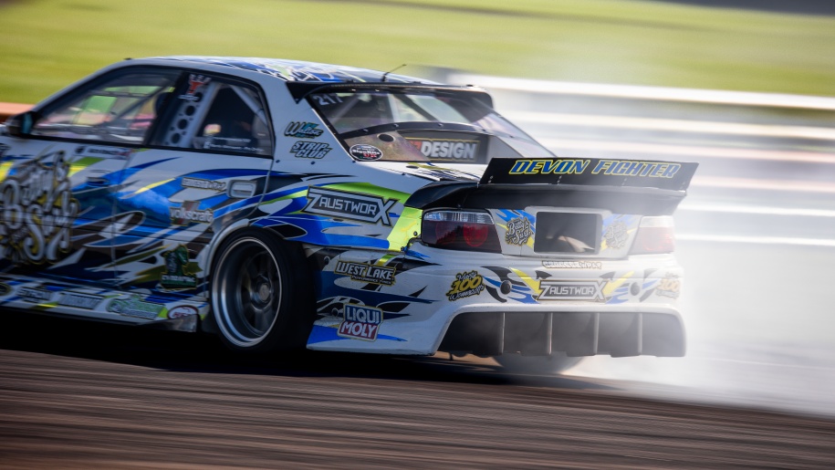 White and blue rally car on a race circuit.