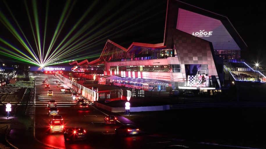 Cars driving along the Christmas light trail at Silverstone Circuit.