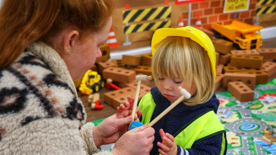 baby dressed with a builders hat and UV jacket