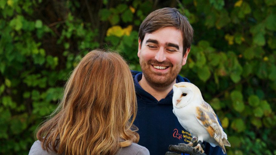 smiling man with owl on shoulder
