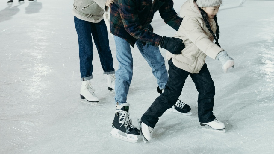 Family skating together on an ice rink.