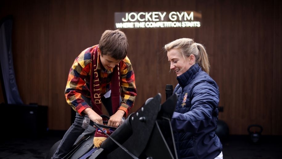 Boy trying out a race horse simulator at Ascot.