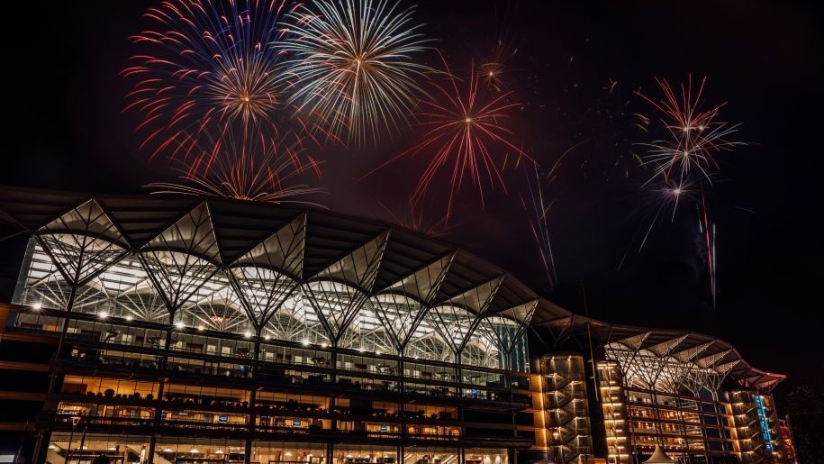 Fireworks exploding in the night sky over the stands at Ascot Racecourse.