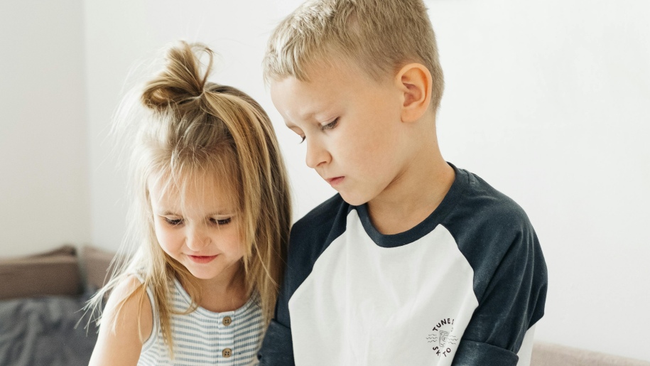 Two children looking at something together.