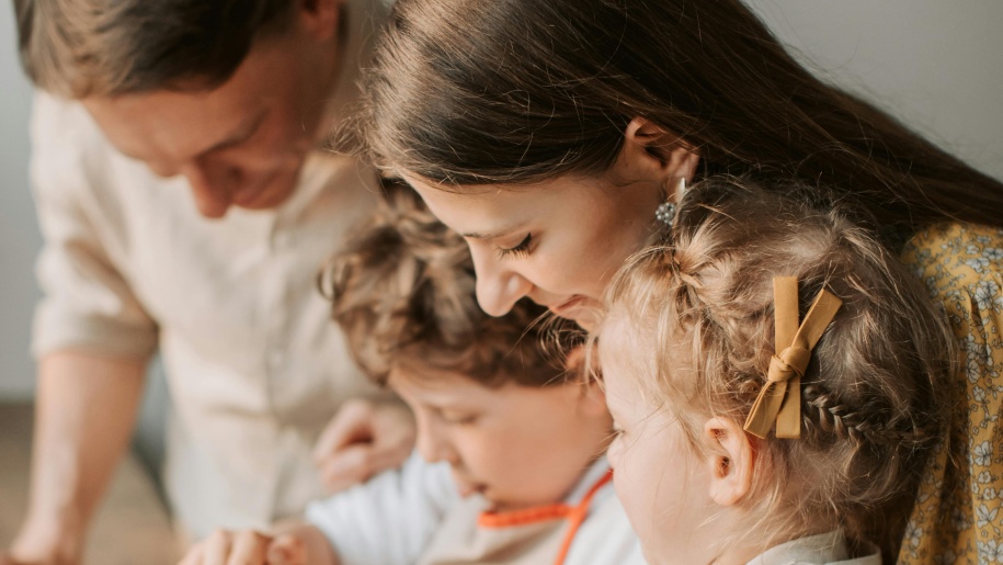 Father, mother and two children looking at something intently.