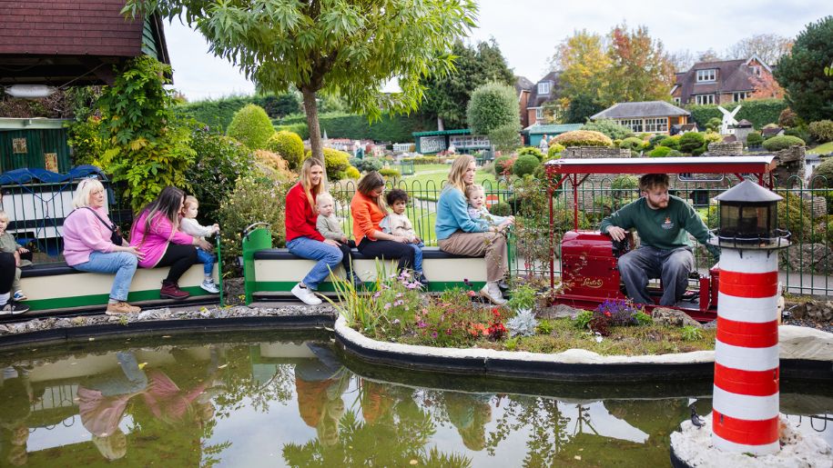 families on a model train ride with little children