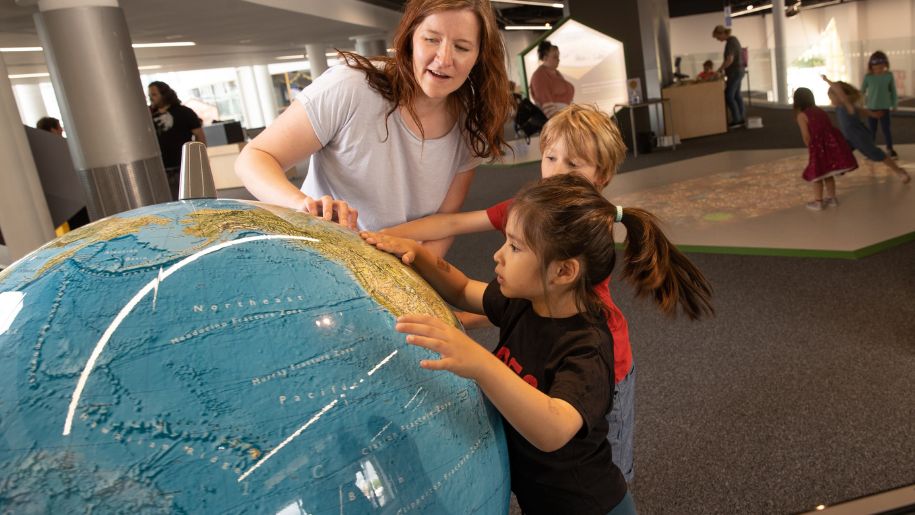 kids looking a a globe