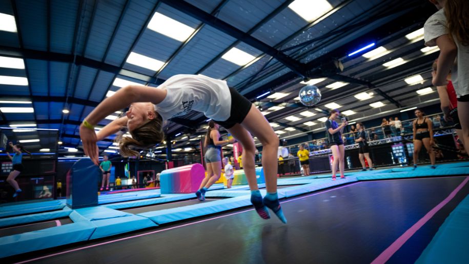 girl does a backflip on a trampoline