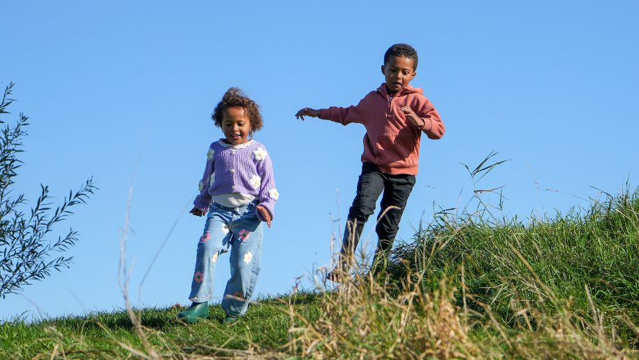 kids running on a sunny day on a green field