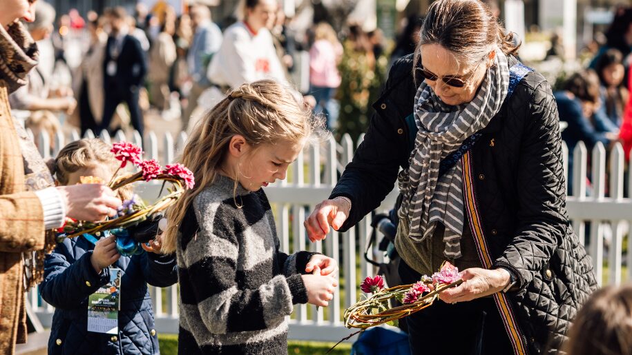 lady and young girl make a weaving wreath in the sunshine