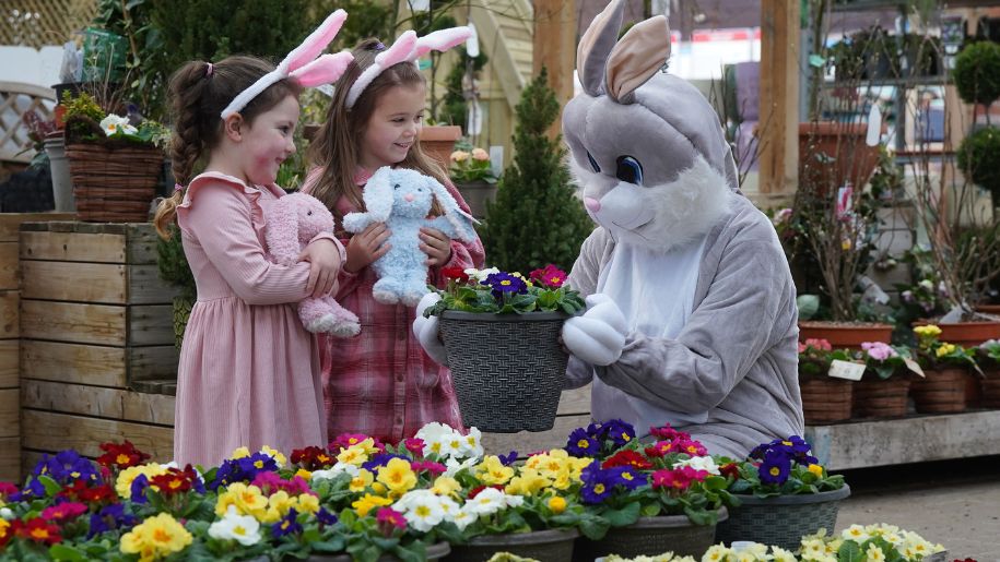 two girls meet the easter bunny, holding rabbits