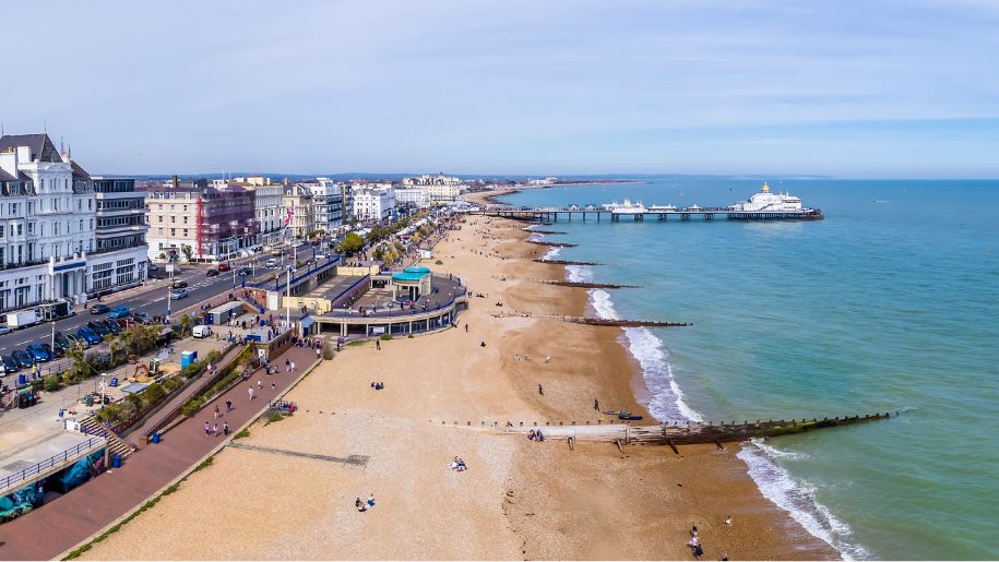 aerial shot of beach, with town on one side and sea on the other