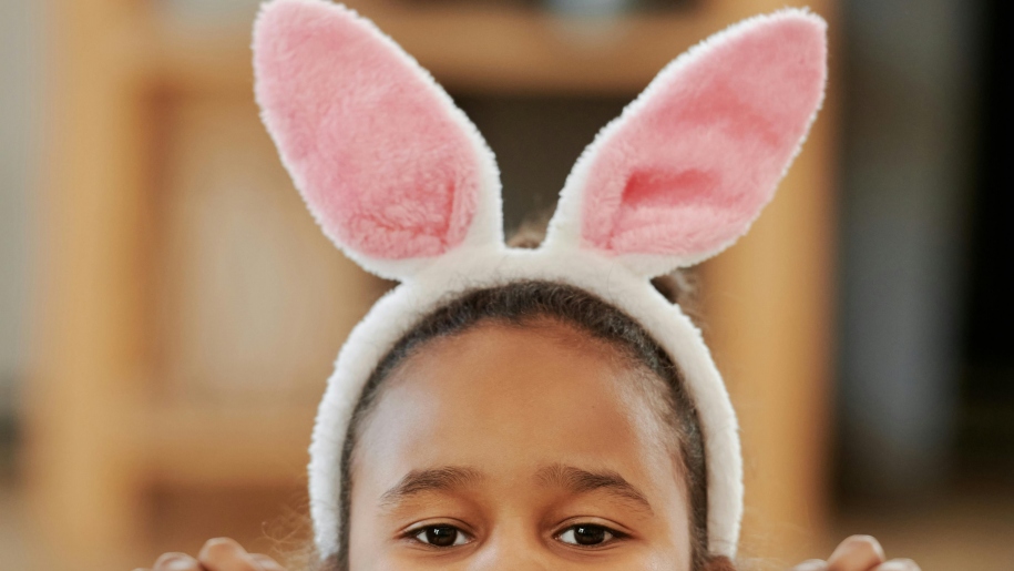 Child wearing pink bunny ears.