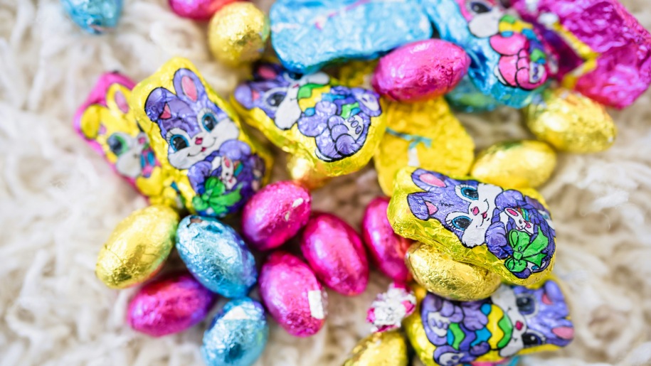 Heap of foil-wrapped small Easter eggs and bunny-shaped chocolates.
