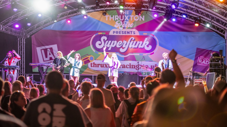 Crowd watching a band on stage at Thruxton Circuit's retro event.