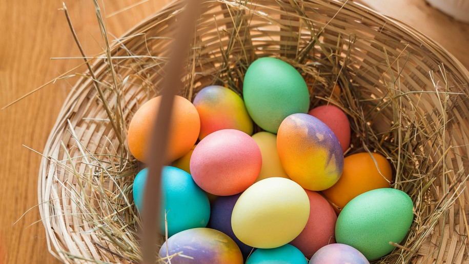 Brightly painted and marbled Easter eggs in a wicker basket.