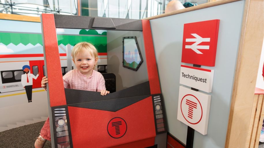 little girl plays in a red bus attraction toy