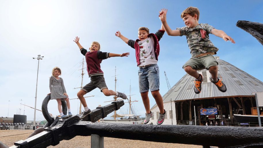 three boys jump in the air off an anchor