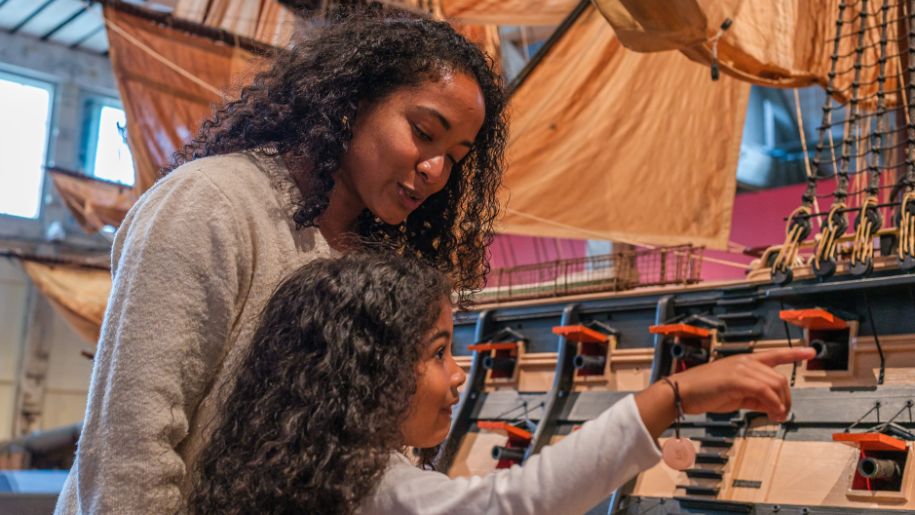 mum and daughter look at indoor exhibits of ships