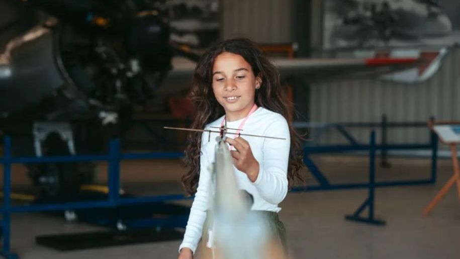 girl holds a model aeroplane