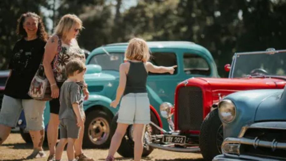 family look at old fashioned cars