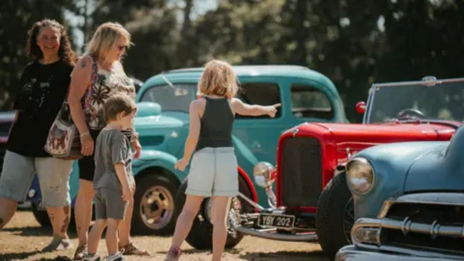 Family looking at a line-up of cars at Shuttleworth.