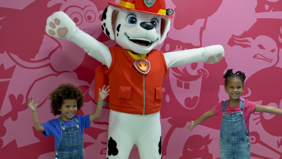 two children stand with paw patrol character