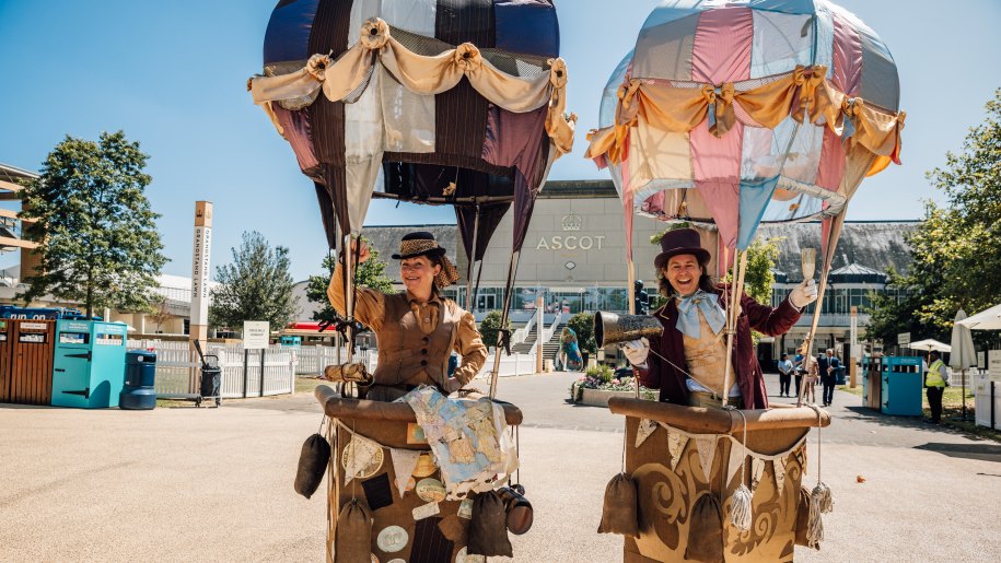 Entertainers at Ascot Racecourse in elaborate model hot air balloons on the ground.