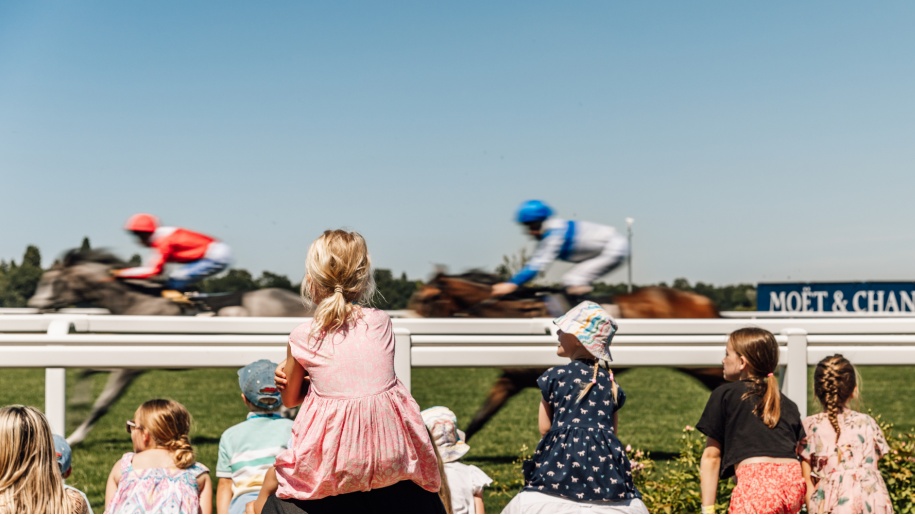 Families watching racing at Ascot in summer.