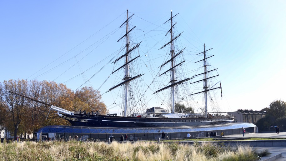 A clipper ship with three masts in a dry dock.