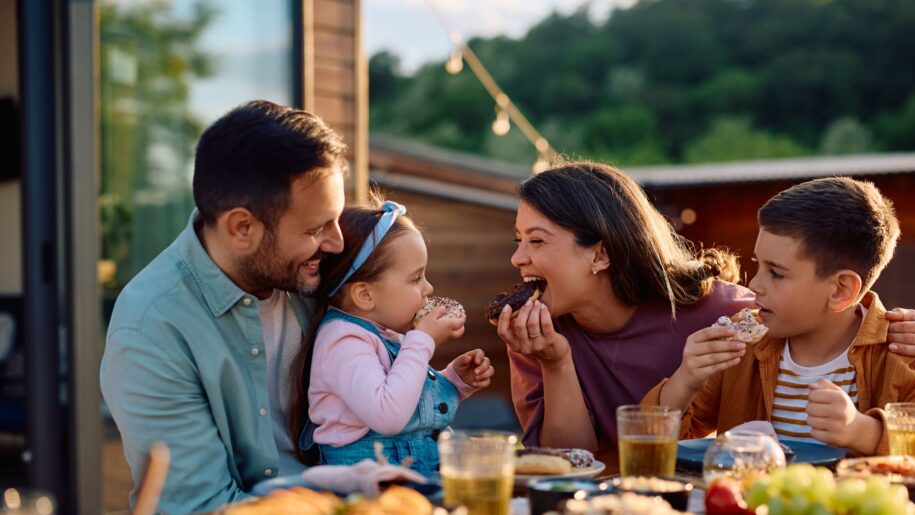 family sit outside eating