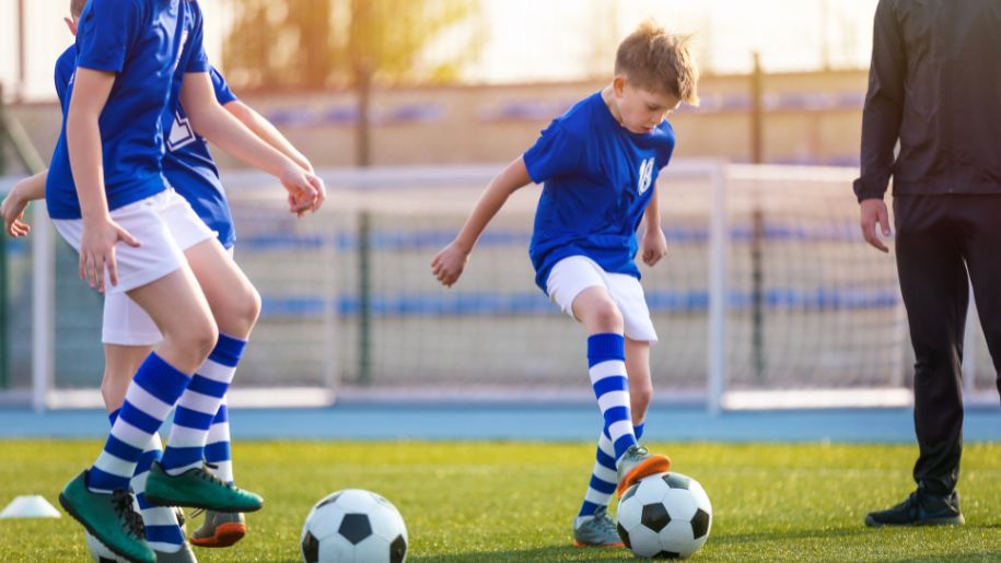 boys in blue kit play football
