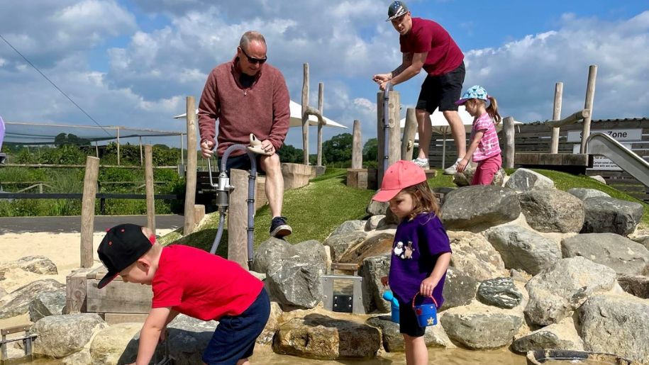 children and fathers play with water features at farmer palmers