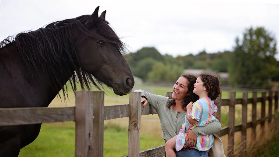 mother and daughter look at horse