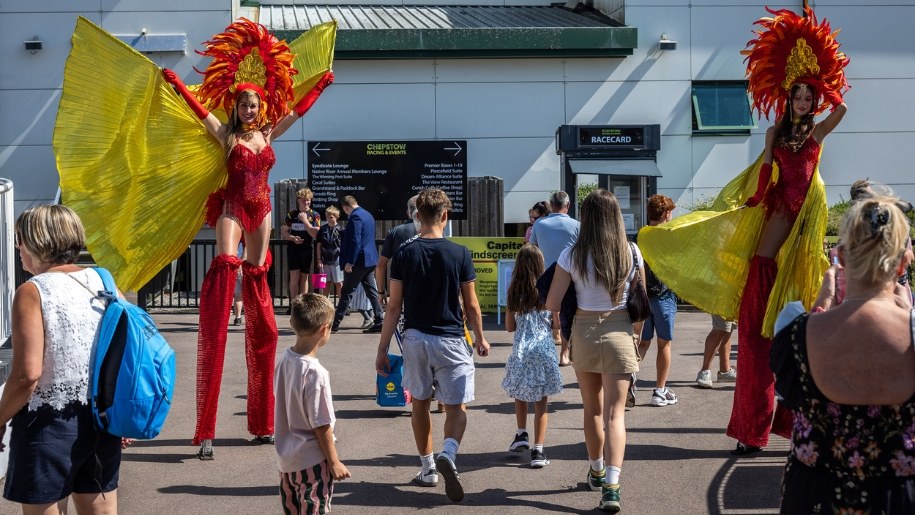 Stilt-walkers moving through crowds of people.