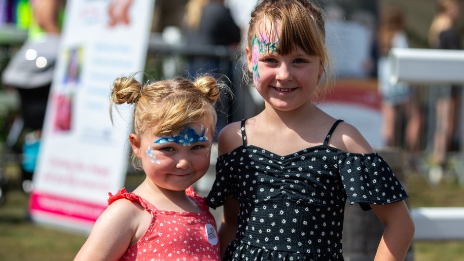 Two little girls with their faces painted.