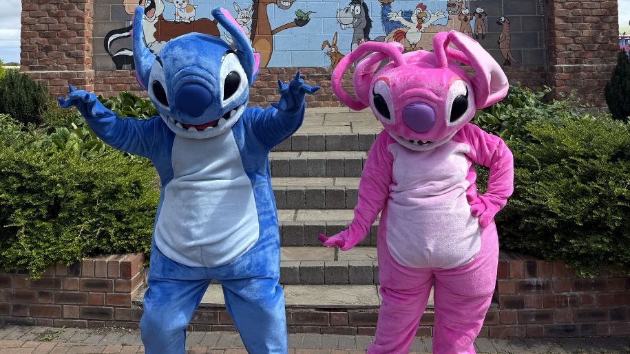 two people dressed in a blue alien costume and a pink alien costume