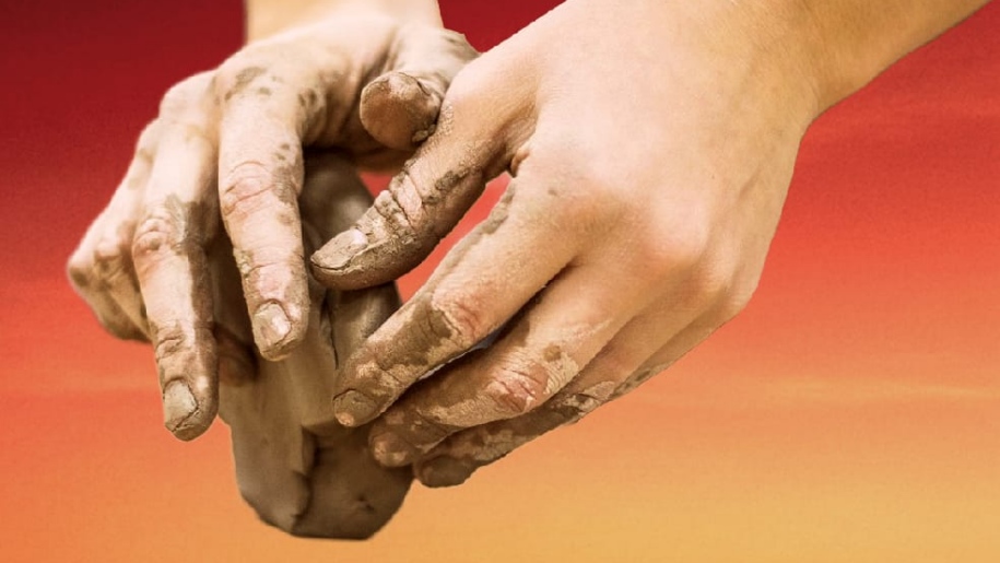 Hands moulding clay.