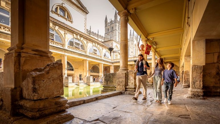 Family exploring the Roman Baths on a summer day out.