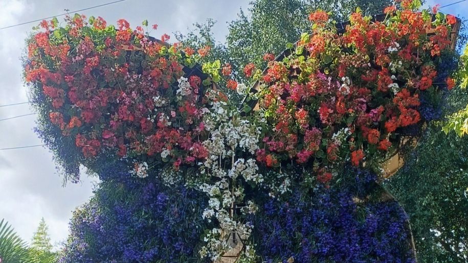 Red, white and blue summer floral artwork in shape of a butterfly.