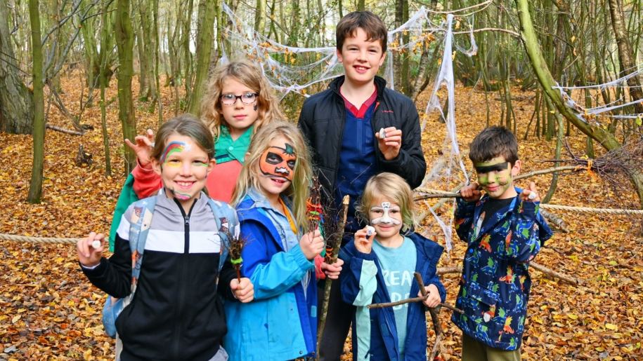 Group of children in woodland during autumn.