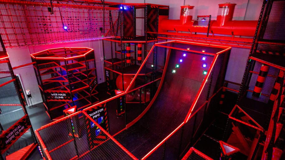 Indoor adventure play equipment including a ramp and climbing obstacles.