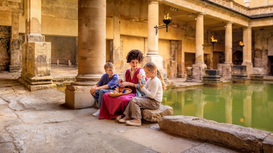 Costumed character with two young visitors at The Roman Baths.