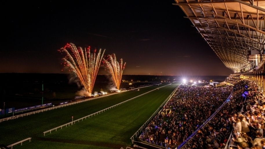 Firework display at Ascot being watched by crowds in the stands.