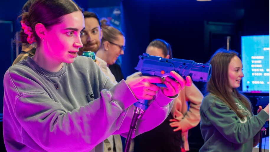Girl playing a shooting game at an indoor arcade.