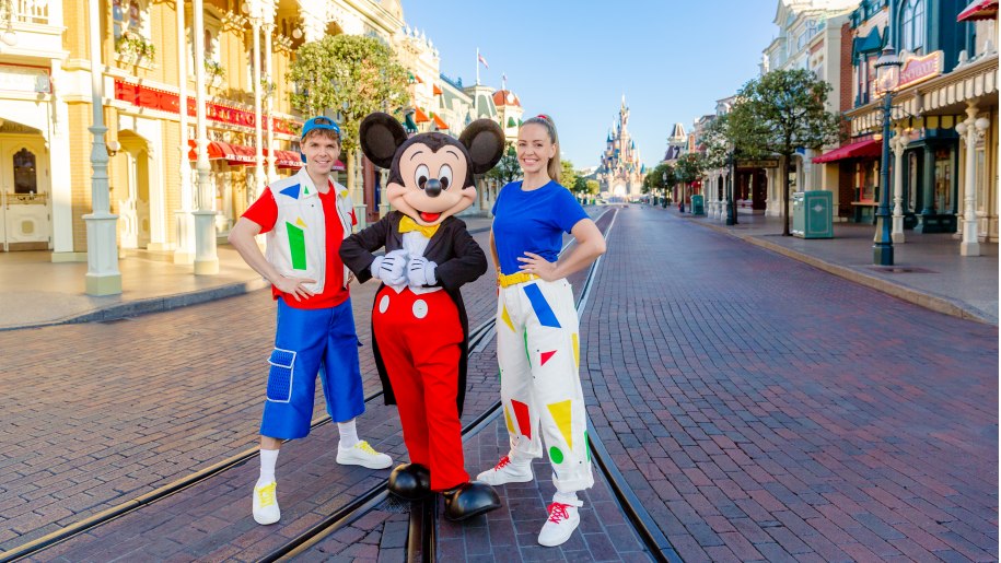 Mickey Mouse with two performers on a street at Disneyland Paris.
