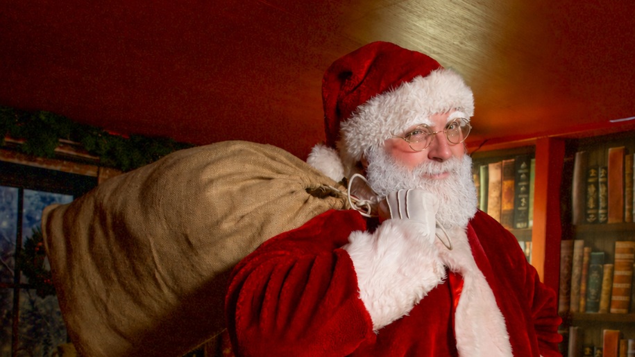 Father Christmas in traditional red costume carrying a sack over his shoulder.